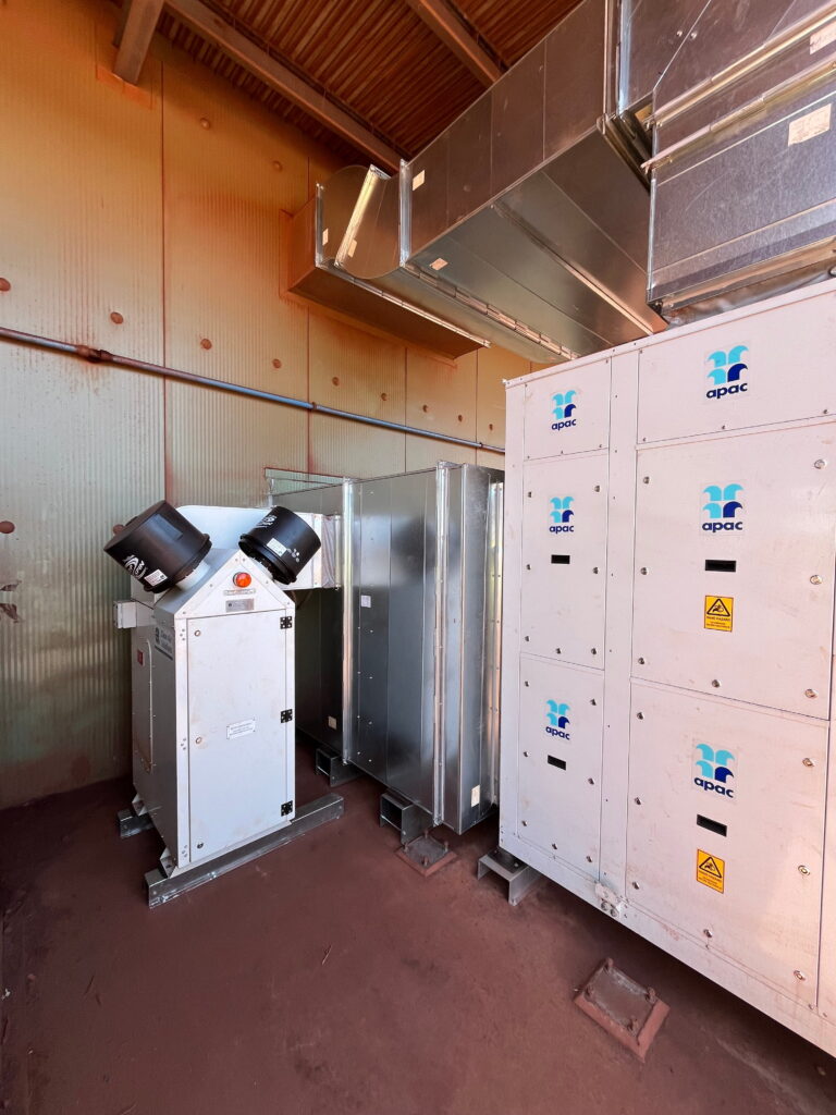 Completed 170 kW APAC commercial HVAC package unit with integrated pressurisation system and ductwork inside a Port Hedland mining facility plant room.