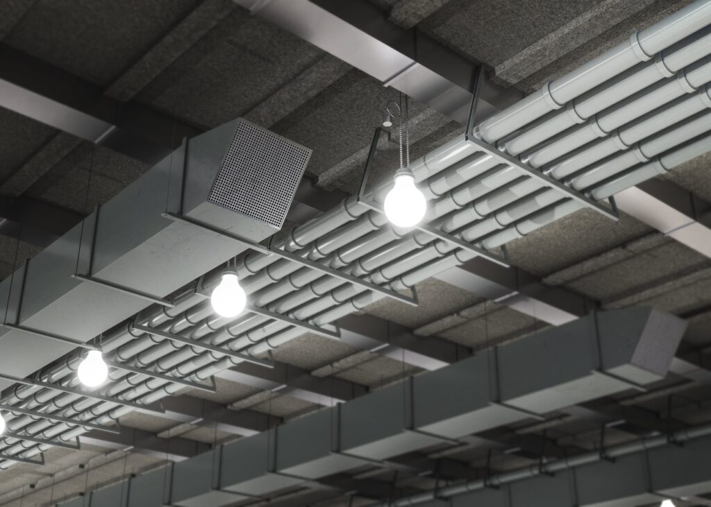 Ceiling View with Industrial Lighting, Ductwork, and Cable Trays in Warehouse