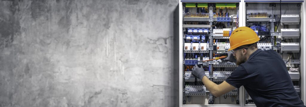 Electrician  Working on a Commercial Switchboard with Precision Tools