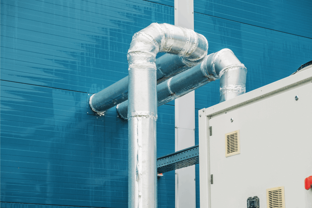 Insulated Metal Cooling Pipes Mounted on the Exterior Wall of a Commercial or Industrial Building